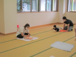 先生によるベビーマッサージのお話を 赤ちゃんをあやしながら聞きました